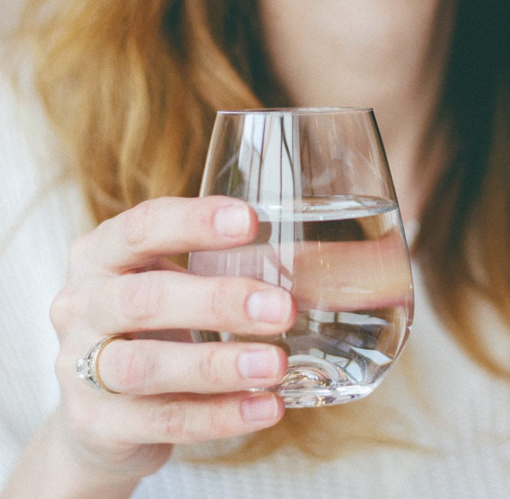 Girl holding a glass of water. Glass of water